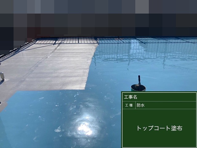 甲府市で屋上防水にトップコートを塗装する様子