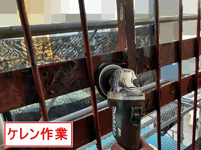 甲府市で屋上の鉄部手すり・鉄部柵に、電動工具（サンダー）でケレン作業（研磨・目粗し）する様子