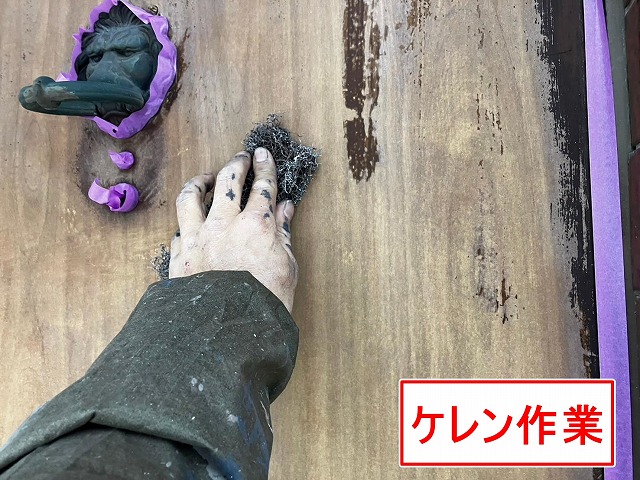 甲府市で木部の玄関扉塗装で、高圧洗浄・ケレン作業を行い下地処理する様子