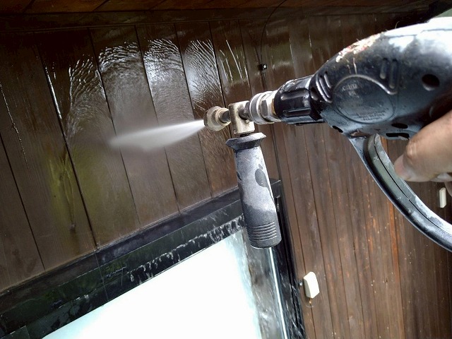 北杜市で木部外壁（木製の外壁）を塗装する際に高圧洗浄を行う様子