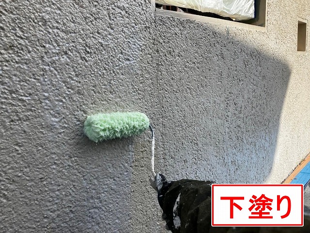 笛吹市でクラック（ひび割れ）の目立つ擁壁に塗装（下塗り）を行う様子