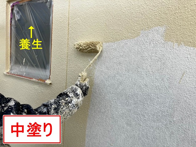 甲府市で下塗り後のモルタル外壁に仕上げ塗装（中塗り）を行う様子