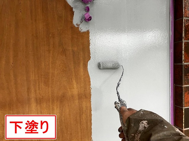 甲府市で木部の玄関扉に下塗りを行う様子
