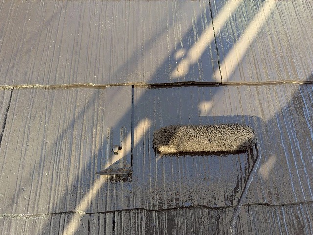 笛吹市でスレート屋根にファインパーフェクトベストで中塗り塗装を行う様子