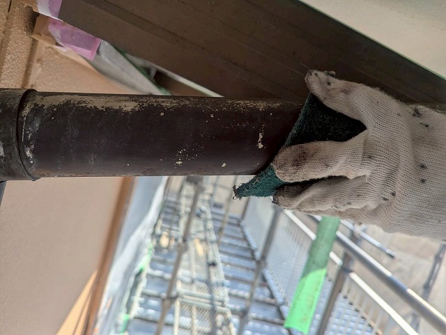 西八代郡市川三郷町で色あせた雨樋（軒樋・竪樋）を塗装する際に、ケレン作業（目粗し）を行う様子