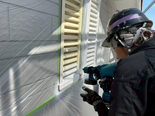 南アルプス市で黄ばみの目立つヤギリ（通気口・ガラリ・ルーバー）に吹き付け塗装を行う様子