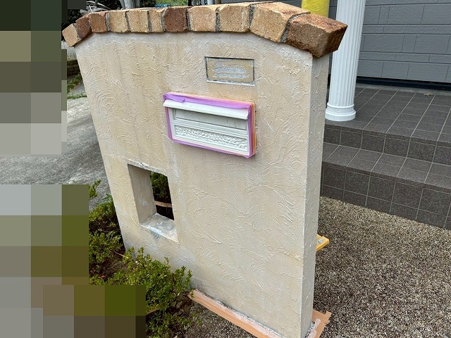 南アルプス市で目隠し擁壁に下塗り(白色)を行う様子