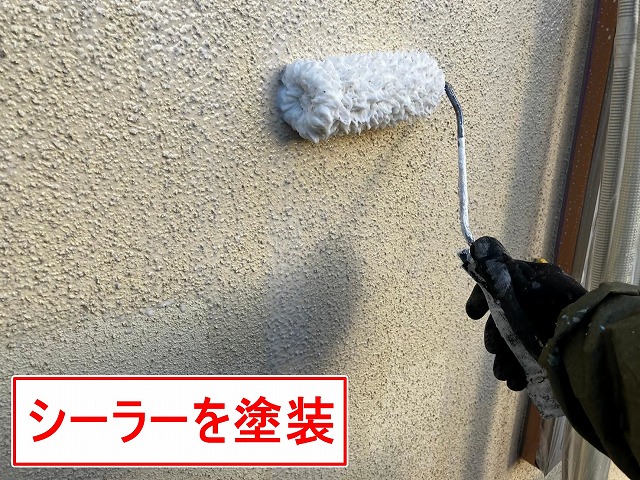 笛吹市でモルタル外壁に水性カチオンシーラーを塗装する様子（下塗り）