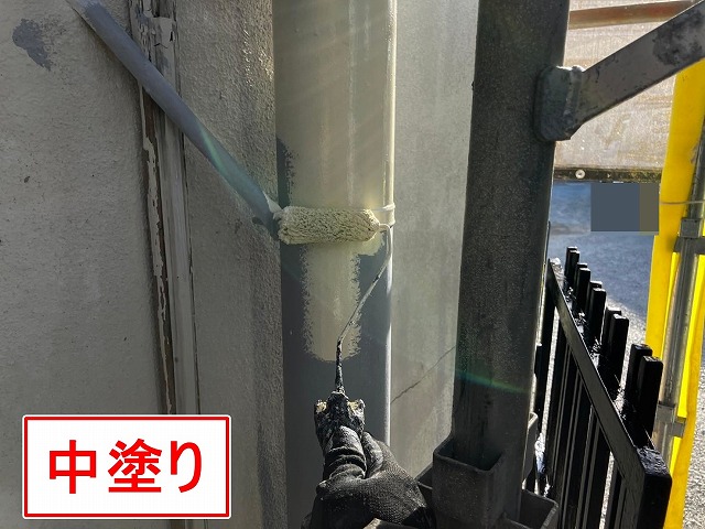 甲府市で塗膜がはがれた竪樋（配管）の塗装で中塗りを行う様子