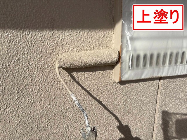 笛吹市でモルタル外壁に仕上げ塗装（上塗り）を行う様子（パーフェクトトップ）