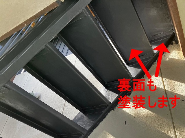 甲府市で塗膜剝がれ・錆びの発生した鉄部階段にケレン作業後、錆止め塗装（下塗り）を行う様子