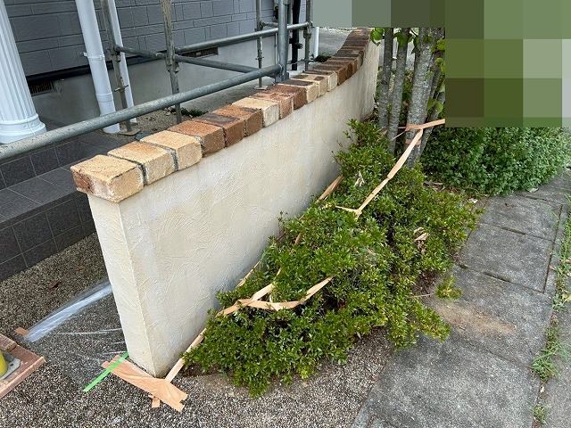 南アルプス市で目隠し擁壁に下塗り(白色)を行う様子