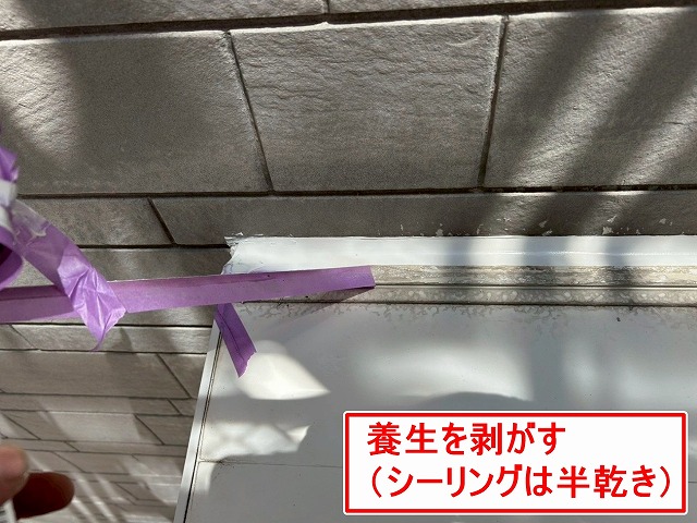 南アルプス市で窓・ドア・換気フードのサッシ廻りにシーリング材が半乾きで養生を撤去する様子（シーリング増し打ち工事）