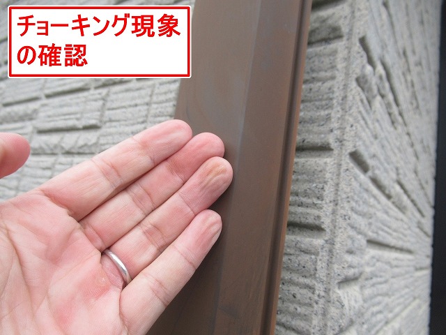 西八代郡市川三郷町で塗膜褪せ（色あせ）た雨樋・配管のチョーキング現象を確認する様子