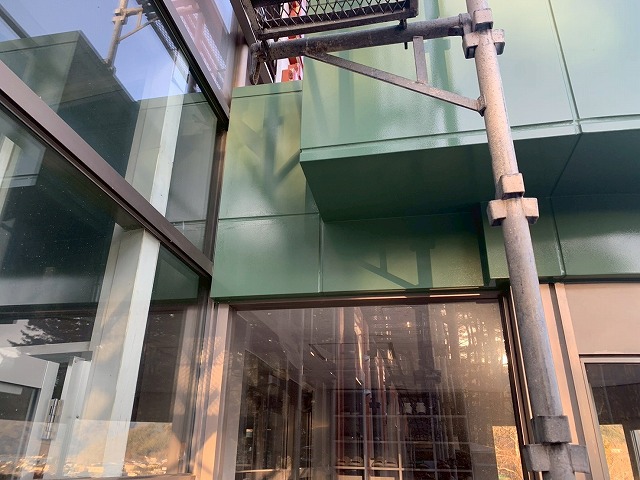 南都留郡富士河口湖町で金属製の玄関上ポーチに仕上げ塗装（シリコン塗装）を行う様子