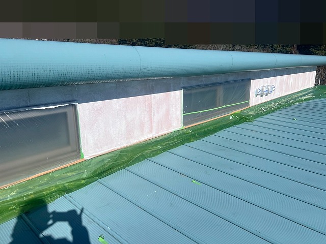 南都留郡富士河口湖町で屋根上部の外壁に下塗りを行う様子