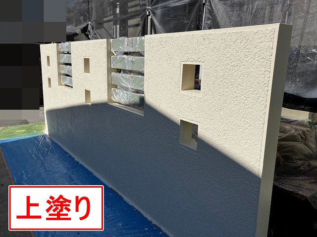 笛吹市でクラック（ひび割れ）の目立つ擁壁に塗装（上塗り）を行う様子