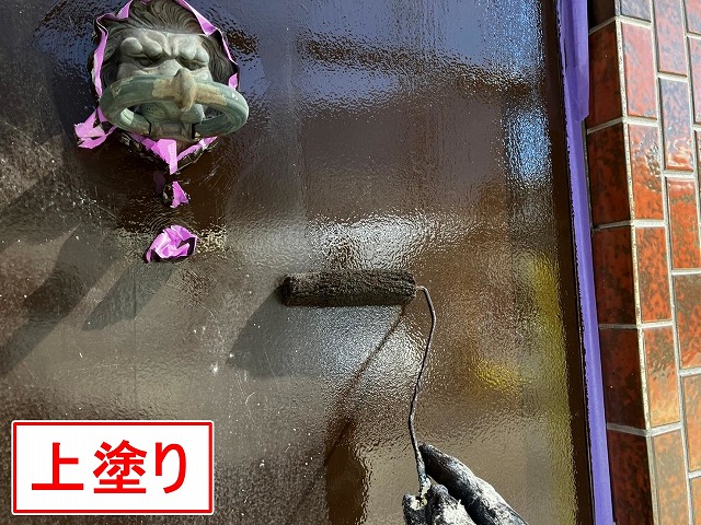甲府市で木部の玄関扉に上塗りを行う様子