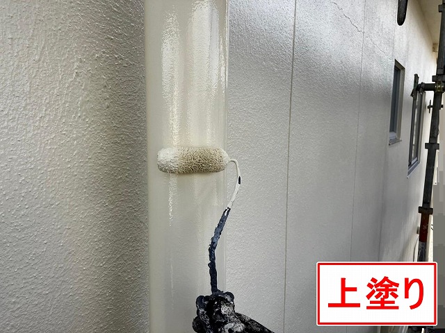 甲府市で塗膜がはがれた竪樋（配管）の塗装で上塗りを行う様子
