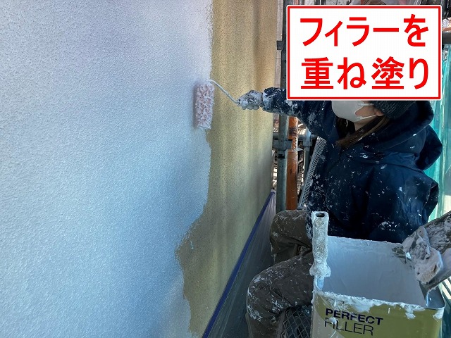 笛吹市でモルタル外壁にパーフェクトフィラーを塗装する様子（下塗り）