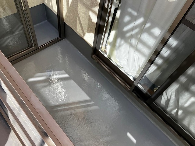 笛吹市でベランダ（バルコニー）の防水面にトップコートを2回塗り重ねる様子