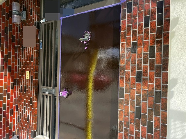 甲府市で木部の玄関扉に上塗りを行う様子
