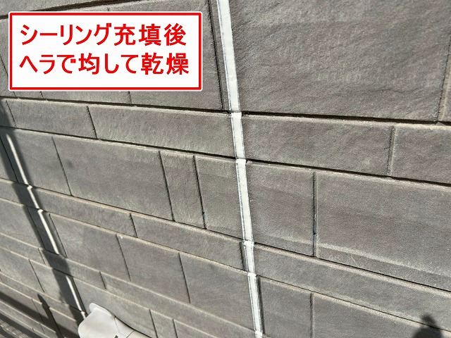 南アルプス市で外壁目地にシーリングを充填後、ヘラで均して乾燥させる様子