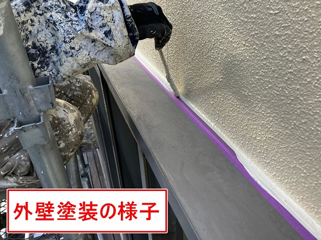 笛吹市で窓サッシ廻り（上部）にシーリング処理後、外壁塗装を行う様子