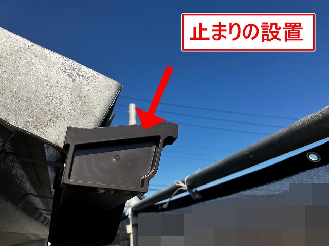 笛吹市で軒樋の端に止まりを設置する様子