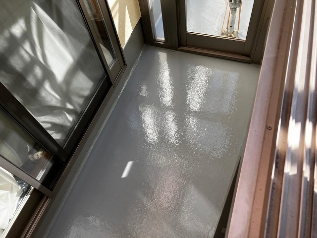 笛吹市でベランダ（バルコニー）の防水面にトップコートを2回塗り重ねる様子