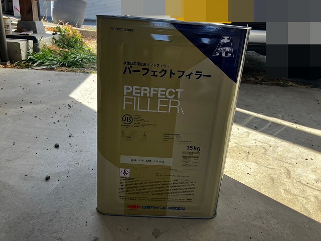 笛吹市でモルタル外壁にパーフェクトフィラーを塗装する様子（下塗り）